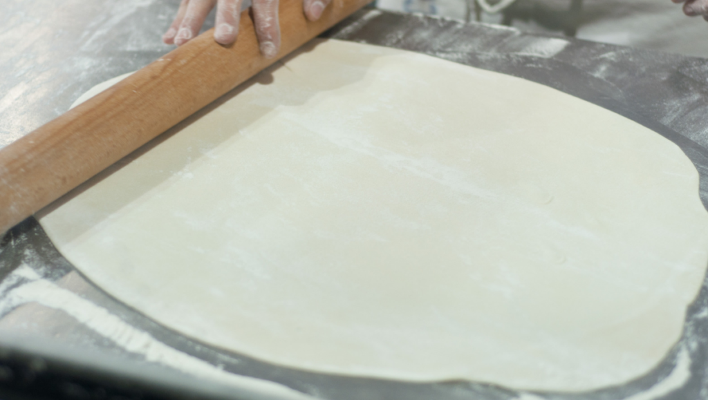 Pizza casera siendo amasada