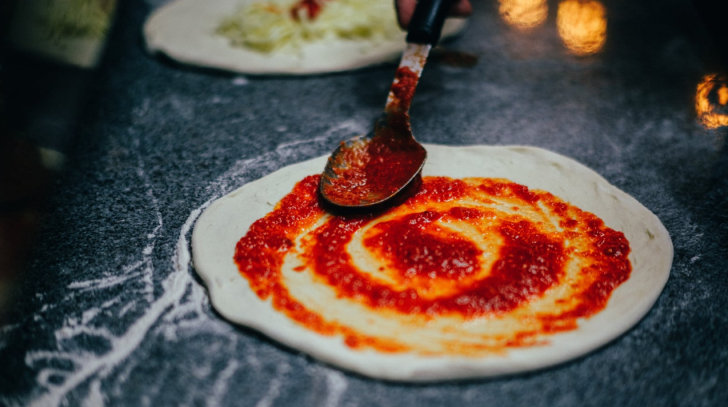 ingredientes para pizza​. Tomate encima de masa casera