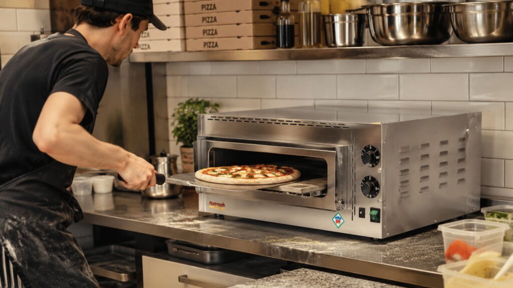 Hombre metiendo una pizza en el horno para pizza